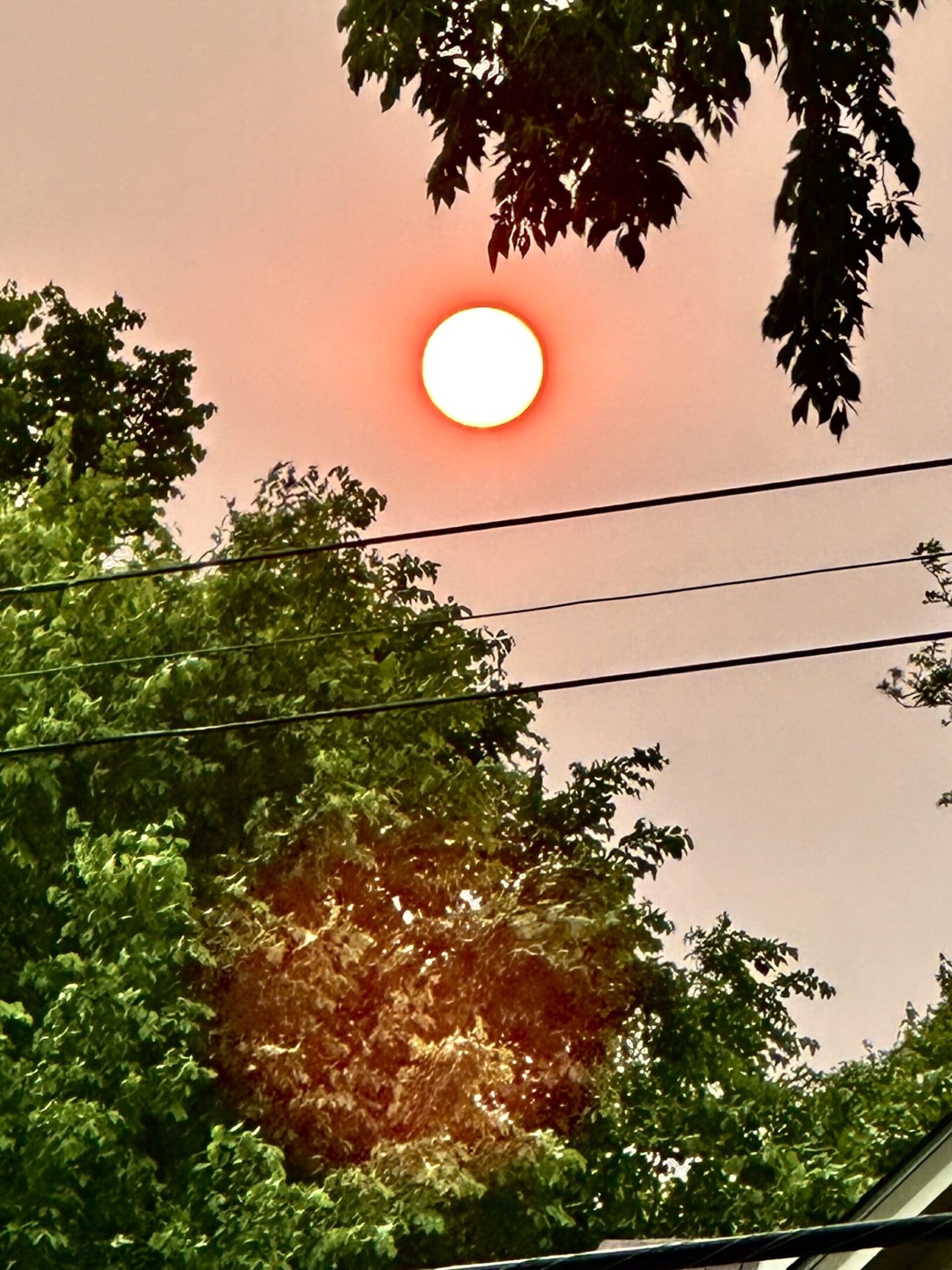 Bright orange sun in cloudy sky