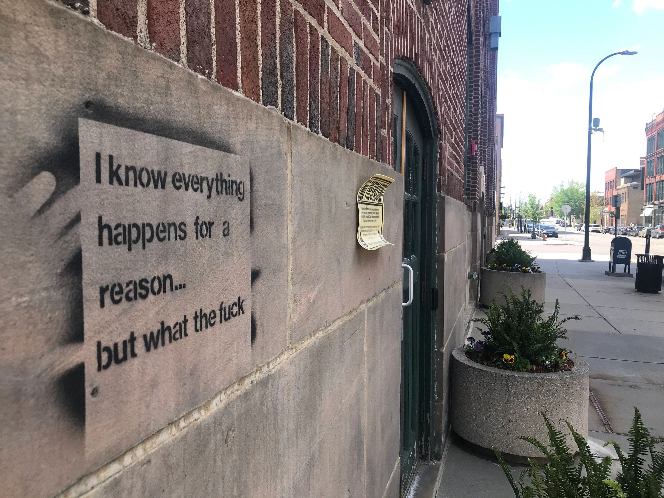 Stencil graffiti on a brick wall expressing confusion with a humorous tone.