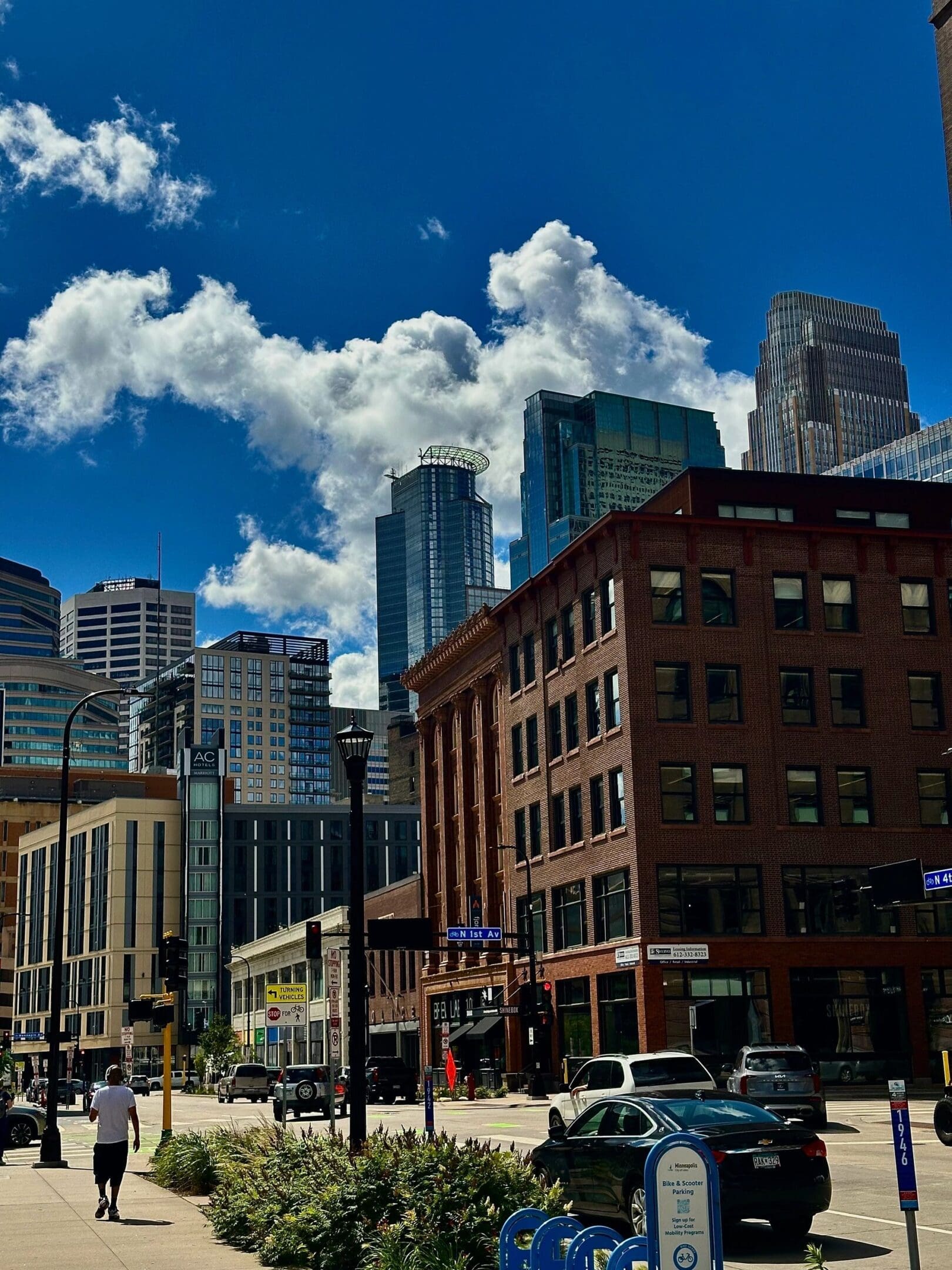 City street with modern and historic buildings under a vibrant blue sky.